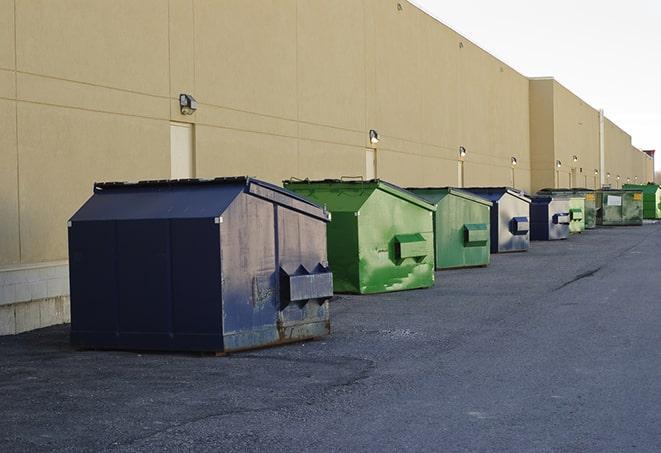 a fleet of red and blue construction dumpsters available for use in Bristow